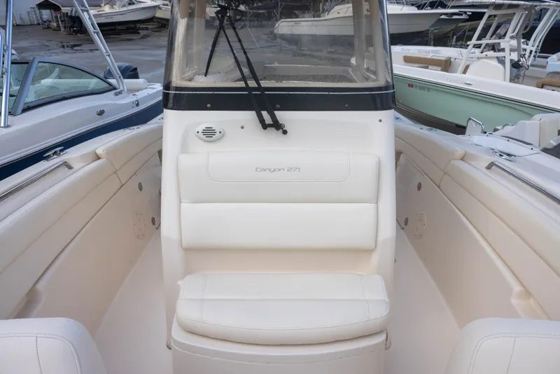 Slide: The Image of The image shows the bow area of a 2021 Grady-White Canyon 271 boat with white upholstery. - 17