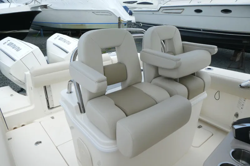 Slide: The Image of 2027 Boston Whaler 250 Outrage boat interior with plush seating and dual outboard engines. - 10