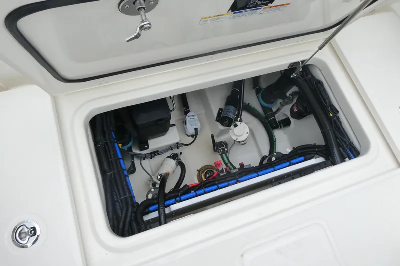 Slide: The Image of 2027 Boston Whaler 250 Outrage boat compartment with wiring and mechanical components. - 8