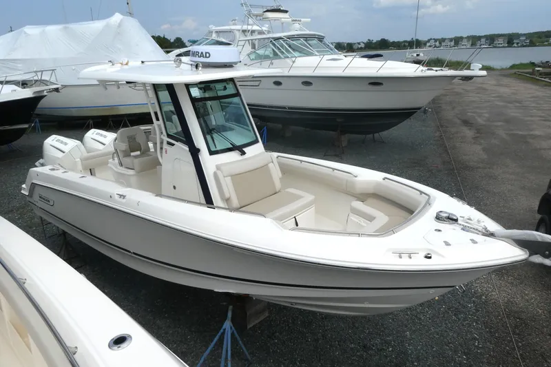 Slide: The Image of 2027 Boston Whaler 250 Outrage boat on display in a marina setting. - 3