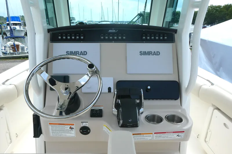 Slide: The Image of 2027 Boston Whaler 250 Outrage helm with Simrad electronics and stainless steel steering wheel. - 9