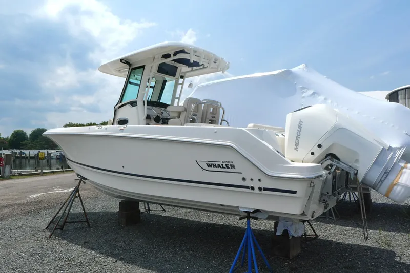 Slide: The Image of 2027 Boston Whaler 250 Outrage boat on display, featuring sleek design and Mercury engine. - 2