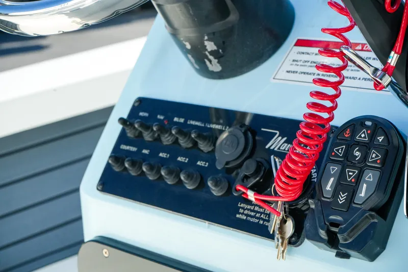 Slide: The Image of Control panel of 2027 Maverick Mirage 18 HPX-V boat with switches and red coiled cord. - 32