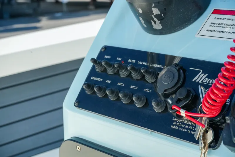 Slide: The Image of Control panel of 2027 Maverick Mirage 18 HPX-V boat with switches and red safety lanyard. - 33