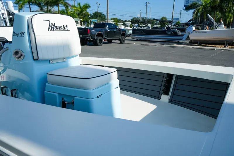 Slide: The Image of 2027 Maverick Mirage 18 HPX-V boat interior with seating and storage, parked outdoors. - 25