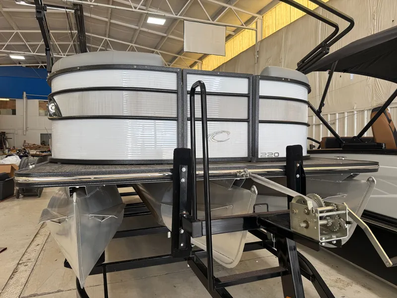 Slide: The Image of A 2022 Crest Classic Platinum 220 SLC pontoon boat on a trailer in a warehouse. - 14