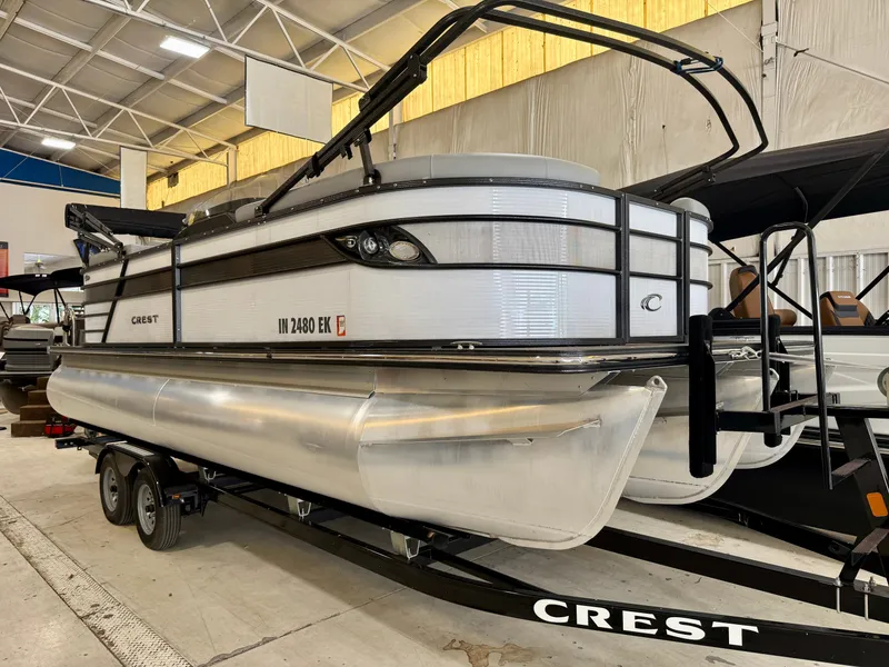 Slide: The Image of A 2022 Crest Classic Platinum 220 SLC pontoon boat on a trailer inside a warehouse. - 13