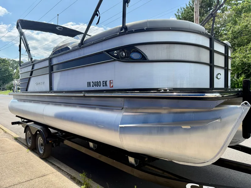 Slide: The Image of A 2022 Crest Classic Platinum 220 SLC pontoon boat on a trailer, ready for transport. - 19
