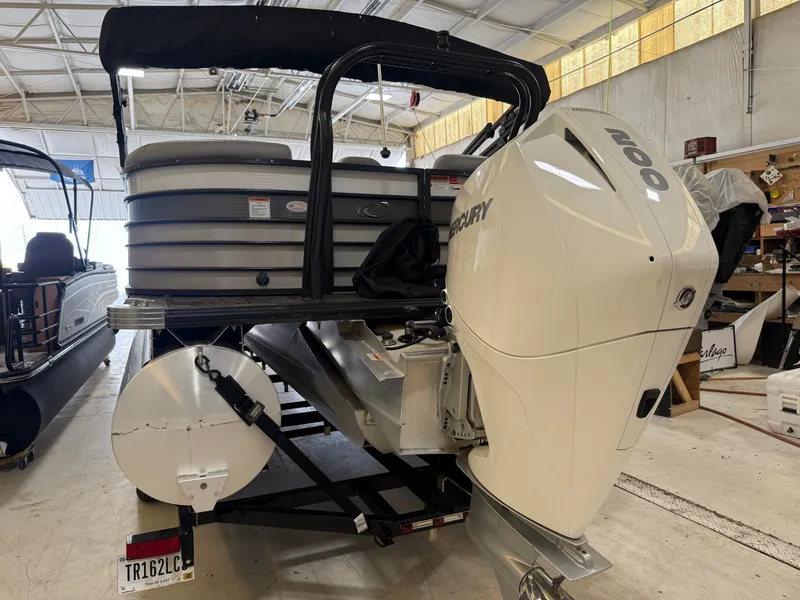 Slide: The Image of A 2022 Crest Classic Platinum 220 SLC pontoon boat in a warehouse. It features a Mercury outboard motor. - 16