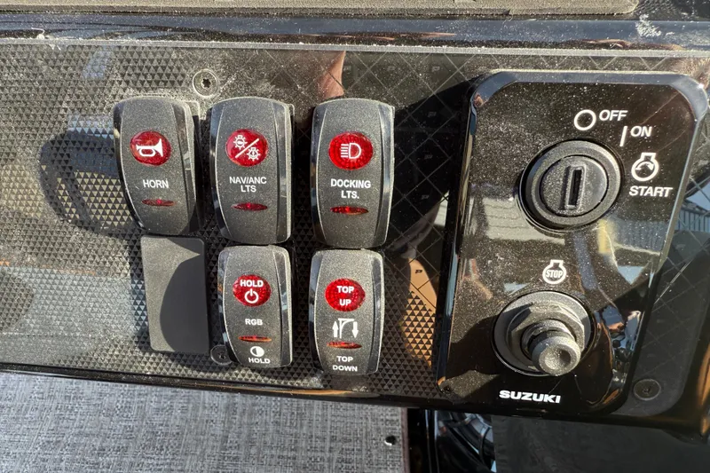 Slide: The Image of Control panel of 2026 Premier 230 SunSation RF boat with various switches and ignition. - 12