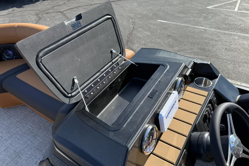 Slide: The Image of 2026 Premier 230 SunSation RF boat dashboard with open storage compartment and steering wheel. - 20