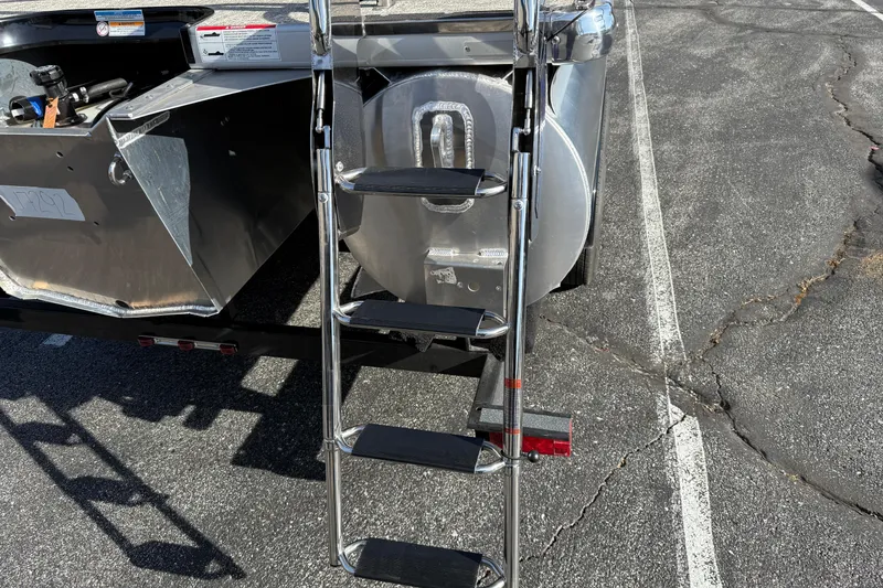 Slide: The Image of Ladder attached to 2026 Premier 230 SunSation RF pontoon boat on asphalt surface. - 30