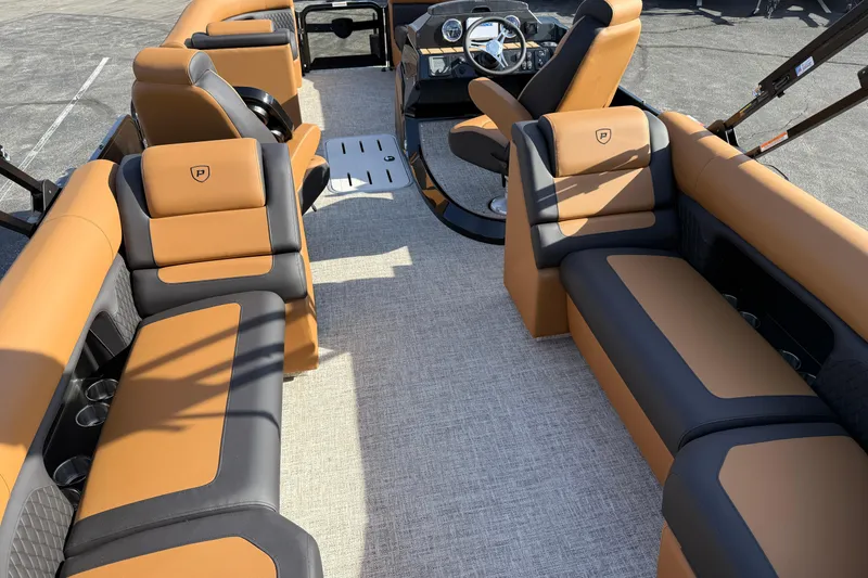 Slide: The Image of Luxurious interior of 2026 Premier 230 SunSation RF pontoon boat with tan and black seating. - 26