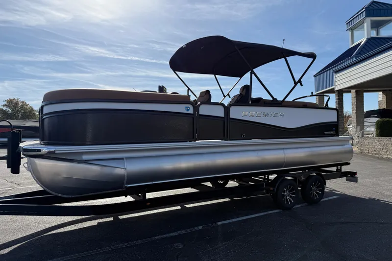 Slide: The Image of 2026 Premier 230 SunSation RF pontoon boat on trailer, parked outdoors under clear sky. - 4
