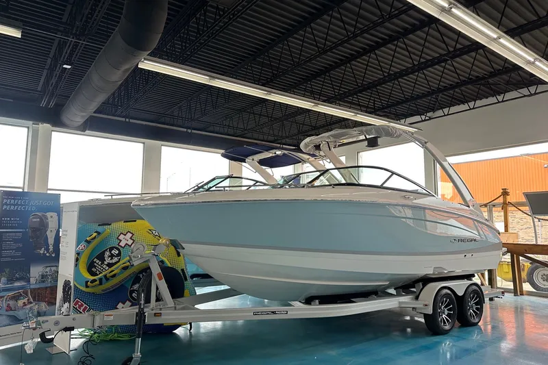 The Image of 2026 Regal LS4 boat displayed indoors on a trailer, showcasing sleek design and modern features. - 0