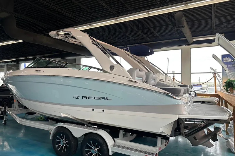 Slide: The Image of 2026 Regal LS4 boat displayed indoors on a trailer, showcasing sleek design and modern features. - 1
