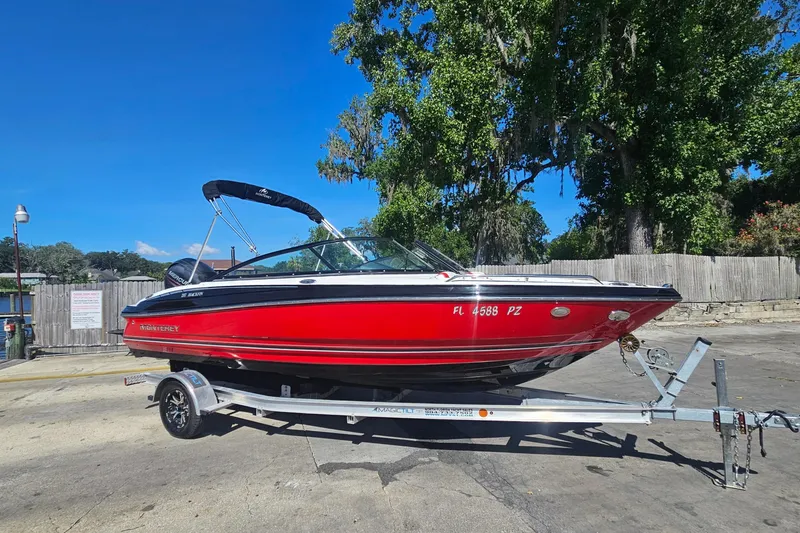 Slide: The Image of Red 2015 Monterey 197 Blackfin boat on trailer, parked outdoors under clear blue sky. - 2