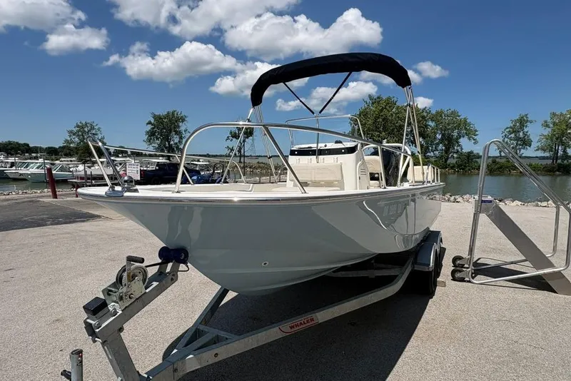 Slide: The Image of 2022 Boston Whaler 190 Montauk boat on trailer by a lakeside under blue sky. - 3