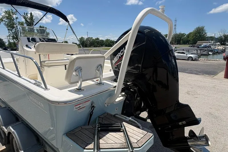 Slide: The Image of 2022 Boston Whaler 190 Montauk boat with Mercury outboard motor, docked under clear skies. - 6