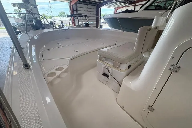 Slide: The Image of 2022 Boston Whaler 190 Montauk interior with seating and storage in a boat garage. - 28