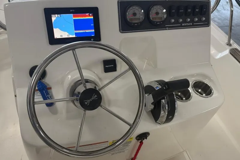 Slide: The Image of 2022 Boston Whaler 190 Montauk boat dashboard with steering wheel and navigation display. - 13