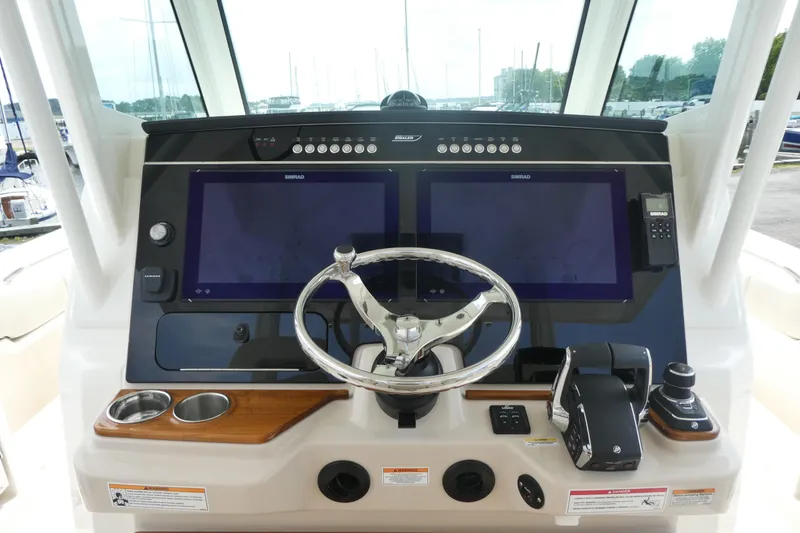 Slide: The Image of Helm of 2027 Boston Whaler 360 Outrage with dual screens and modern controls. - 8