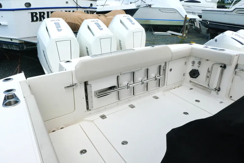 Slide: The Image of 2027 Boston Whaler 360 Outrage boat deck with triple outboard engines, docked in marina. - 4