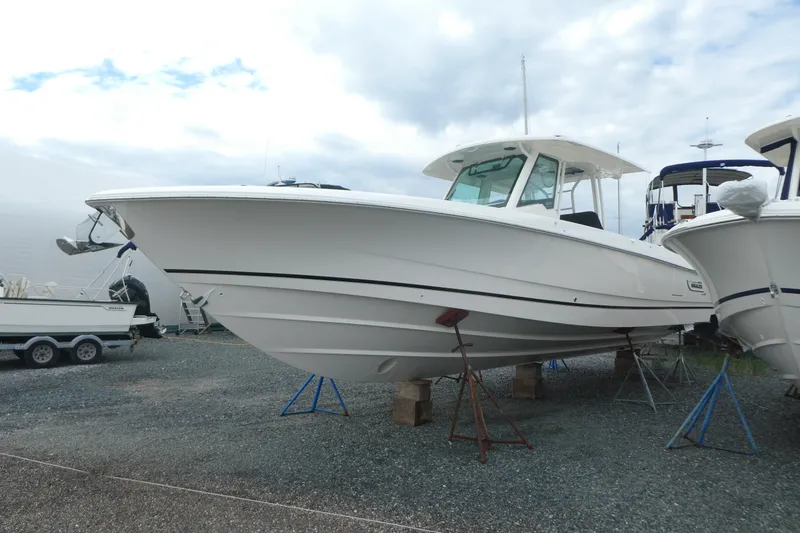 Slide: The Image of 2027 Boston Whaler 360 Outrage boat on stands, displayed outdoors under cloudy sky. - 3