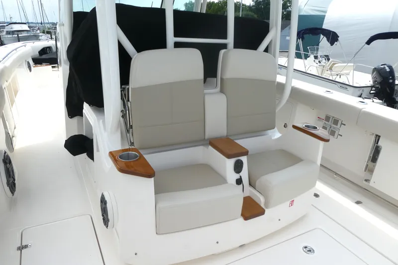 Slide: The Image of 2027 Boston Whaler 360 Outrage boat interior with cushioned seating and cup holders. - 6