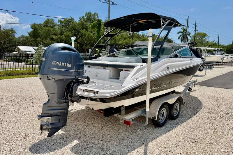 Slide: The Image of 2020 Regal 21 OBX boat with Yamaha outboard motor on a trailer in a sunny setting. - 5