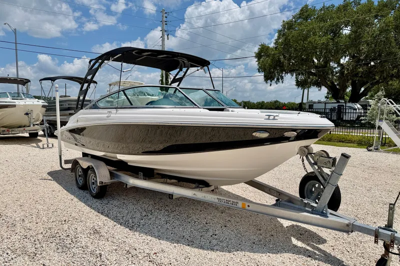 Slide: The Image of 2020 Regal 21 OBX boat on trailer, parked outdoors under a sunny sky. - 3