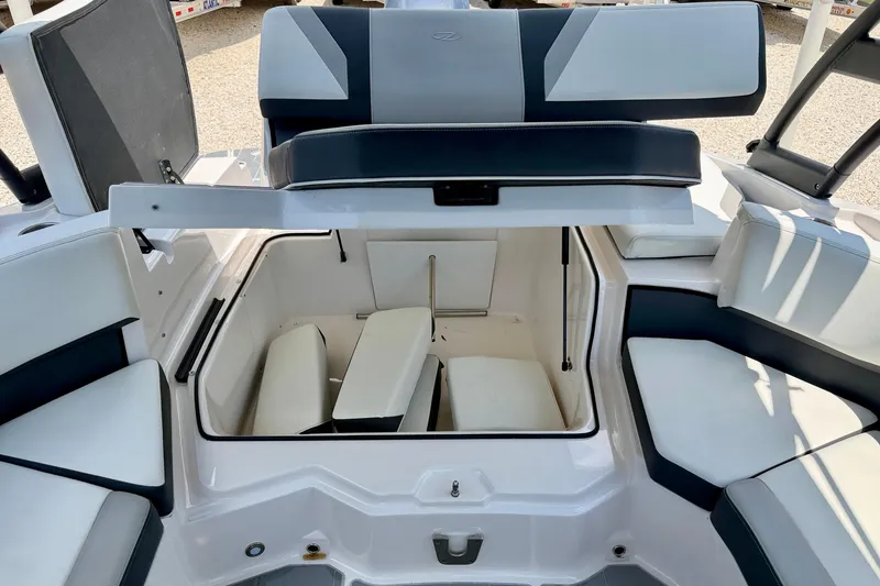 Slide: The Image of 2020 Regal 21 OBX boat interior with open storage compartment and cushioned seating. - 30