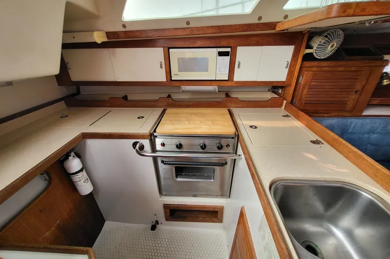 Slide: The Image of 1997 Catalina 36 MkII yacht kitchen with stove, microwave, and sink. - 8