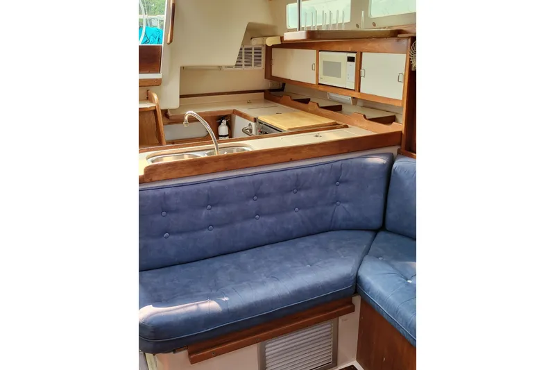 Slide: The Image of Interior of 1997 Catalina 36 MkII sailboat with blue seating and compact kitchen area. - 10