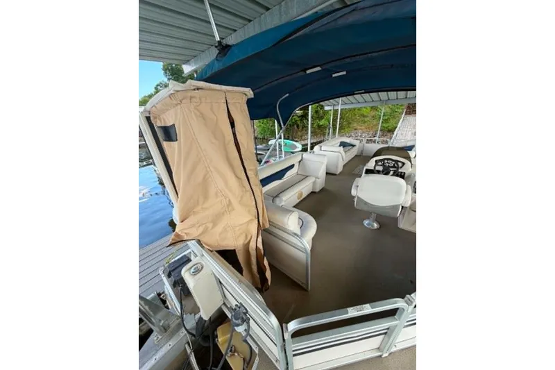 Slide: The Image of 2009 Premier 240 SunSpree pontoon boat with canopy and seating, docked by the water. - 4