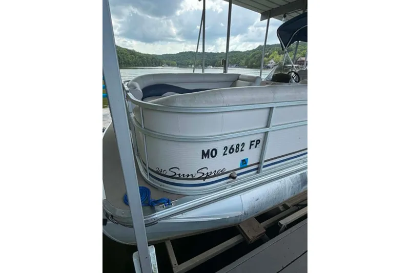 Slide: The Image of 2009 Premier 240 SunSpree pontoon boat docked on a lake under cloudy skies. - 7