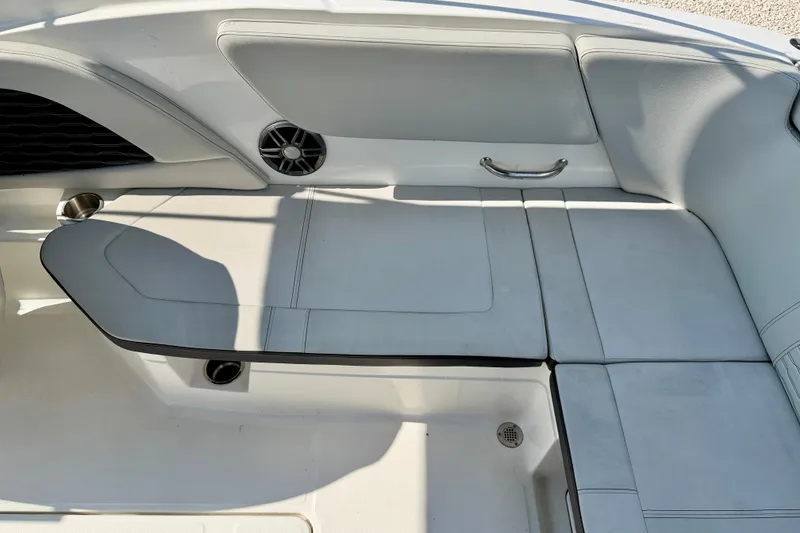 Slide: The Image of 2022 Sea Ray SPX 230 Outboard boat interior with white cushioned seating and speaker. - 20