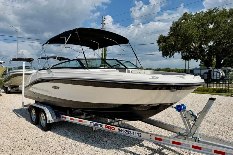 Slide: The Image of 2022 Sea Ray SPX 230 Outboard boat on trailer, parked outdoors under a cloudy sky. - 3