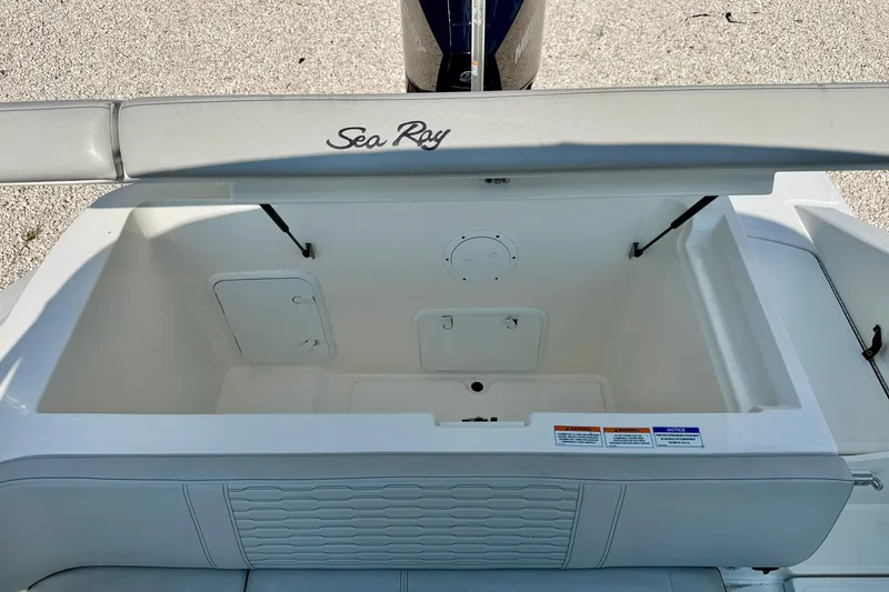 Slide: The Image of 2022 Sea Ray SPX 230 Outboard boat storage compartment with open lid, showcasing spacious interior. - 30