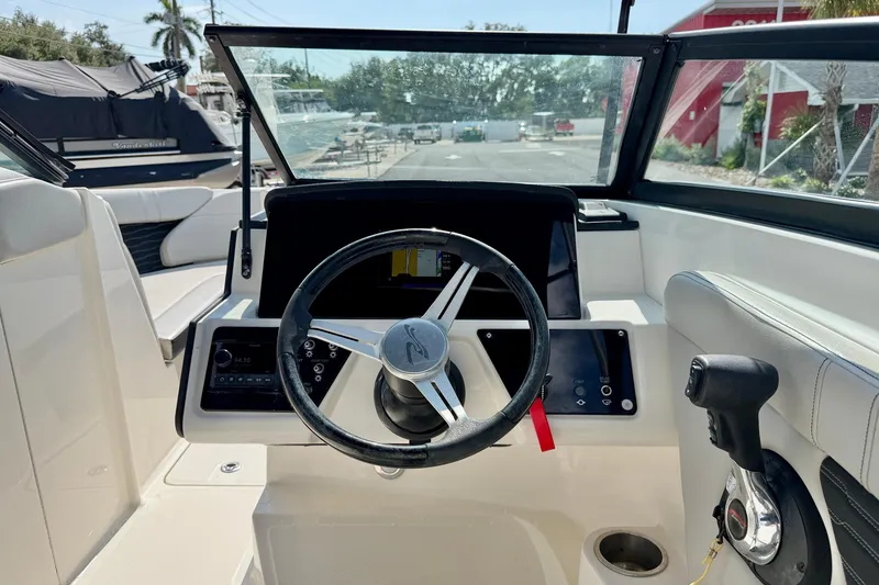 Slide: The Image of 2022 Sea Ray SPX 230 Outboard boat cockpit with steering wheel and control panel. - 13