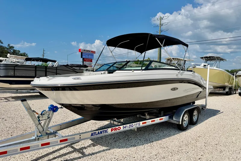Slide: The Image of 2022 Sea Ray SPX 230 Outboard boat on trailer, displayed outdoors under clear sky. - 1