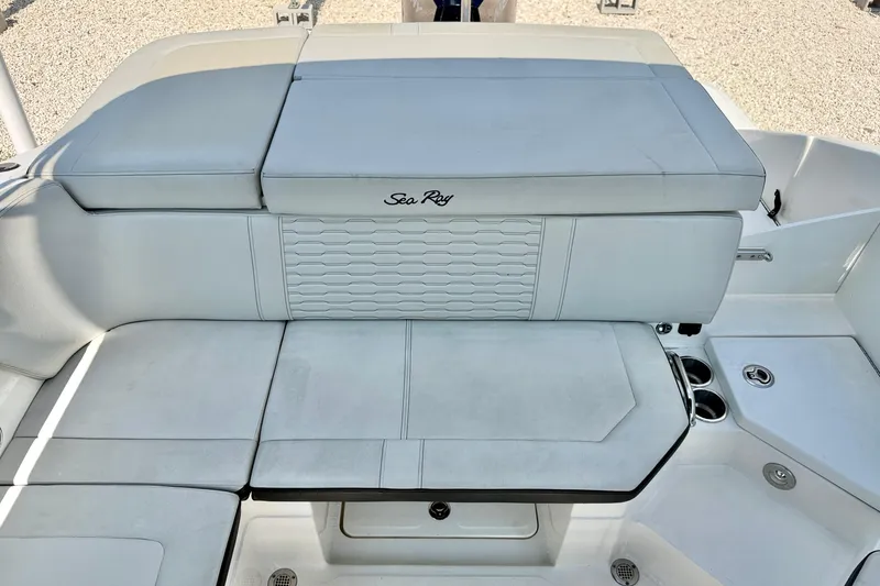 Slide: The Image of 2022 Sea Ray SPX 230 Outboard boat seating area with white upholstery and cup holders. - 22