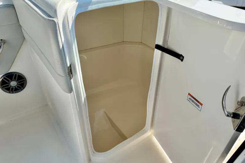 Slide: The Image of 2022 Sea Ray SPX 230 Outboard boat storage compartment with open door and speaker. - 26