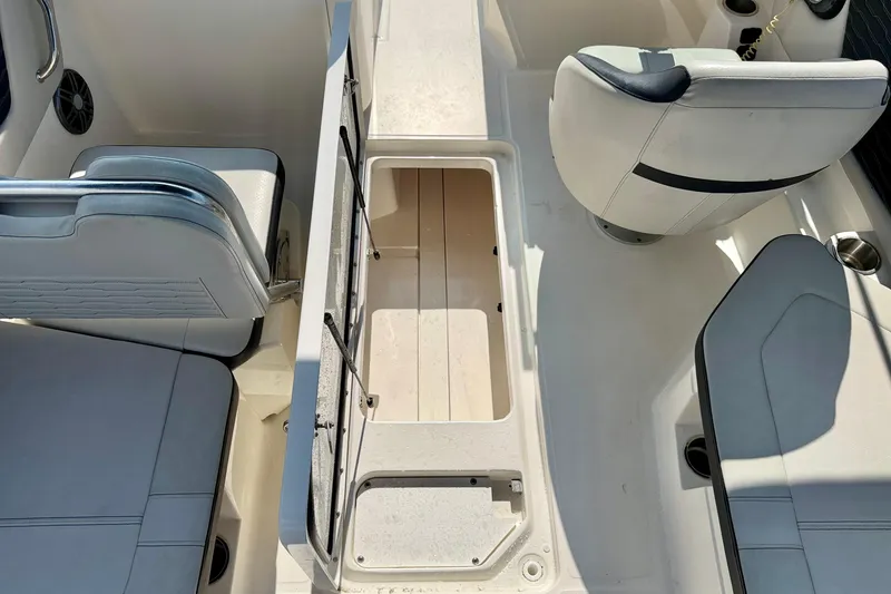 Slide: The Image of 2022 Sea Ray SPX 230 Outboard interior with open storage compartment and seating. - 27