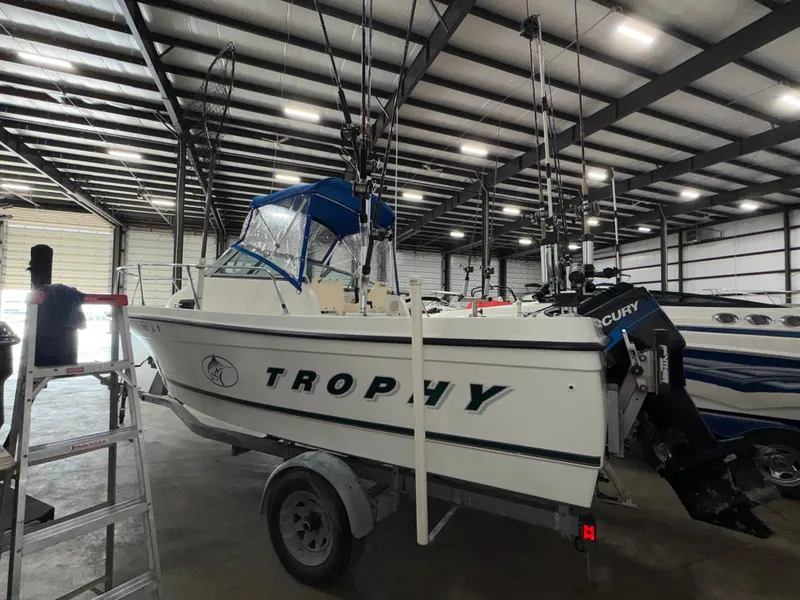 Slide: The Image of A 2000 Bayliner Trophy 2002FF is on a trailer in a warehouse. - 4