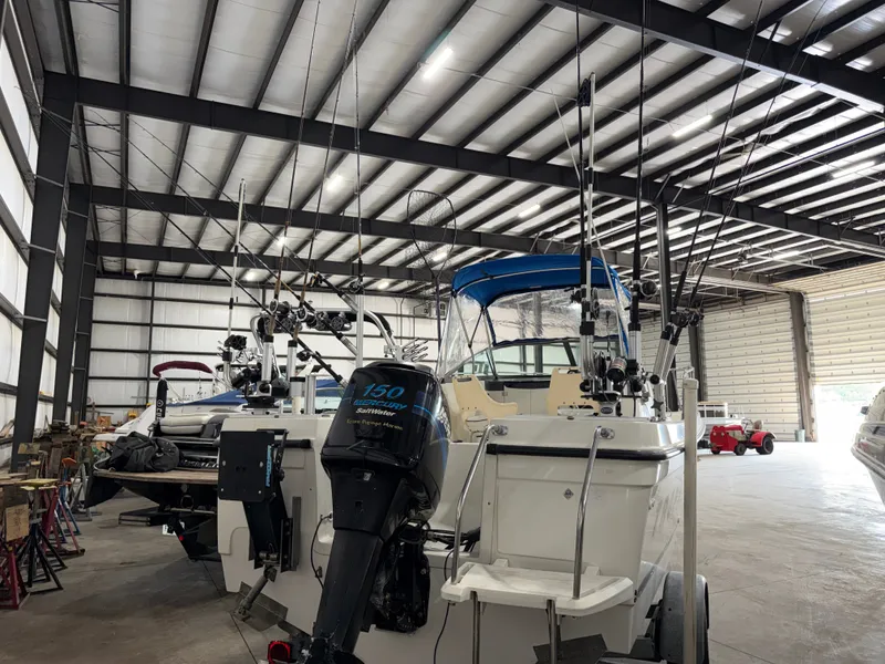 Slide: The Image of A 2000 Bayliner Trophy 2002FF is in a warehouse. Several fishing rods are mounted. - 5
