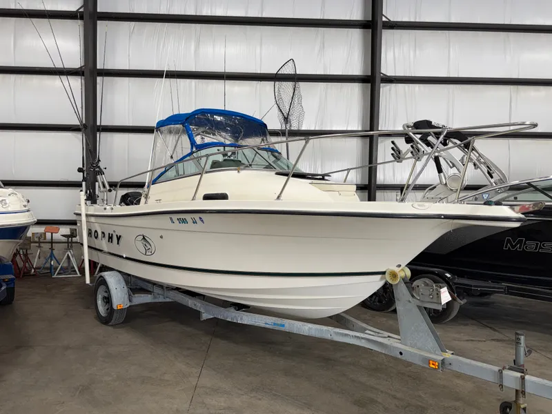 The Image of A 2000 Bayliner Trophy 2002FF on a trailer inside a storage facility. - 0