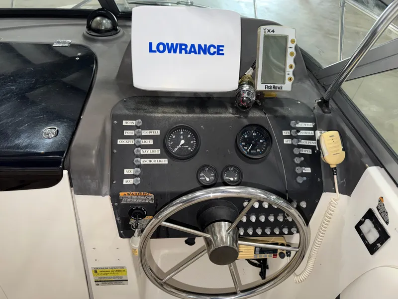 Slide: The Image of The image shows the helm of a Bayliner Trophy 2002FF boat with various instruments and a Lowrance fish finder. - 16