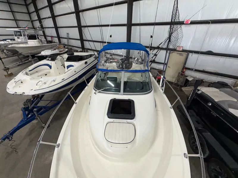 Slide: The Image of A 2000 Bayliner Trophy 2002FF in a storage facility, featuring a blue cover and surrounding boats. - 7