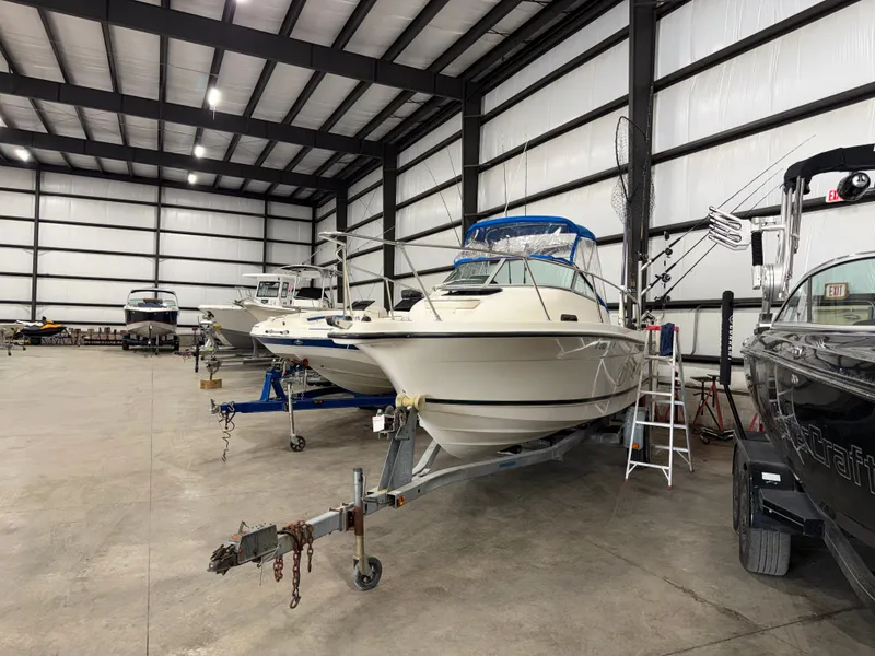Slide: The Image of A 2000 Bayliner Trophy 2002FF sits on a trailer in a large warehouse. - 3